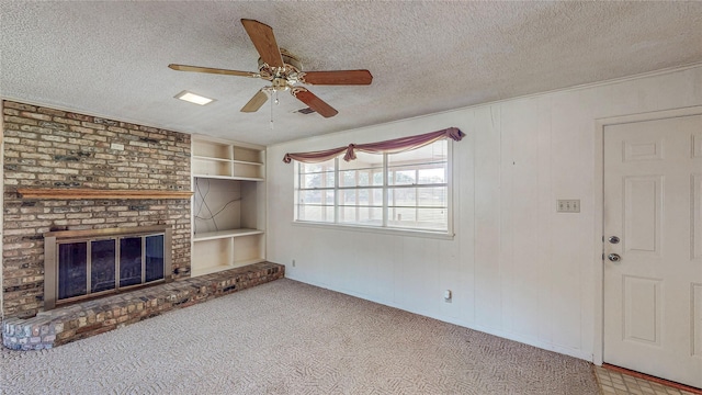 10335 Nolan Dr, Tyler, TX 75709 - unfurnished living room with a ceiling fan, a fireplace, a textured ceiling, carpet flooring, and built in shelves