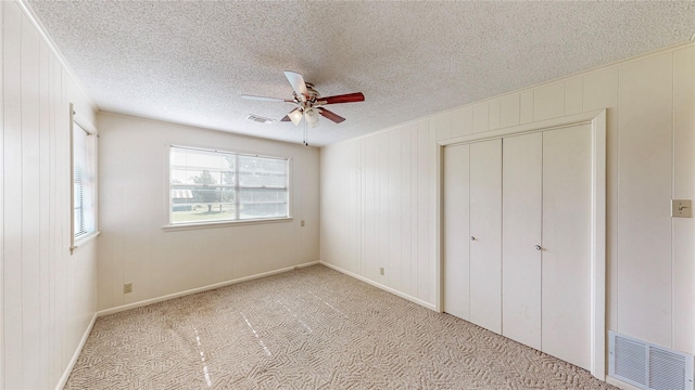10335 Nolan Dr, Tyler, TX 75709 - unfurnished bedroom with a textured ceiling, a closet, carpet flooring, a ceiling fan, and baseboards