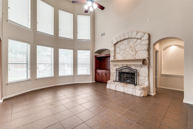 201 Barkley Dr, Hickory Creek, TX 75065 - unfurnished living room with a ceiling fan, dark tile patterned floors, a fireplace, a towering ceiling, and baseboards