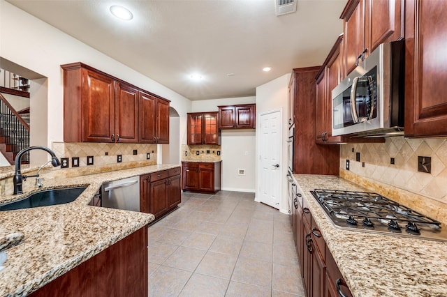 201 Barkley Dr, Hickory Creek, TX 75065 - kitchen with appliances with stainless steel finishes, a sink, light stone counters, decorative backsplash, and recessed lighting