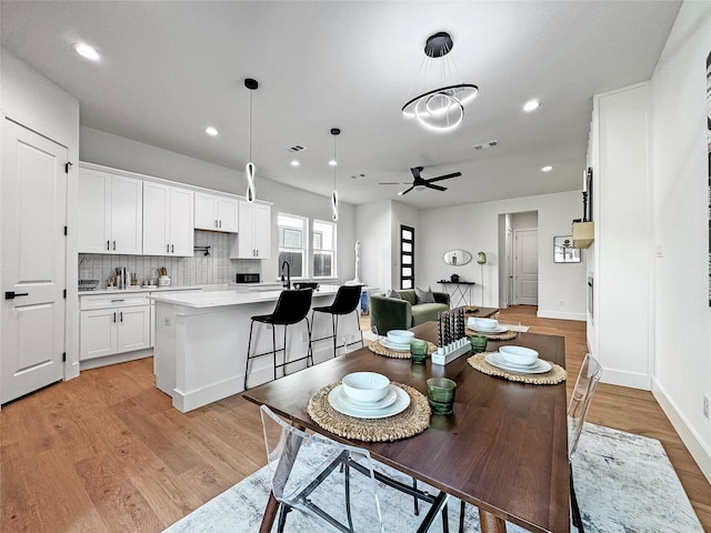 2419 Merlin St, Dallas, TX 75215 - dining area with a ceiling fan, light wood finished floors, recessed lighting, a chandelier, and baseboards