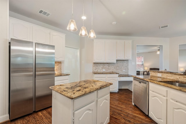 2145 Tartan Trl, Highland Village, TX 75077 - kitchen with stainless steel appliances, dark wood finished floors, light stone counters, decorative backsplash, and white cabinetry