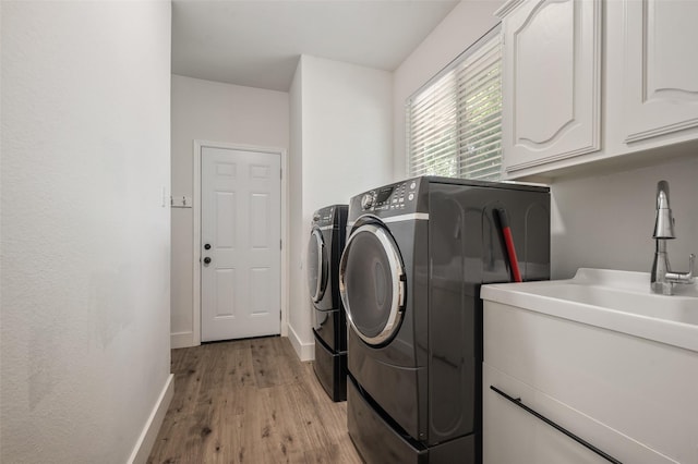 2145 Tartan Trl, Highland Village, TX 75077 - laundry room with washing machine and dryer, cabinet space, light wood-style floors, and baseboards