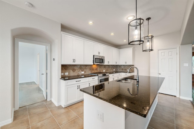 459 Bristol St, Roanoke, TX 76262 - kitchen with stainless steel appliances, a sink, backsplash, light tile patterned flooring, and white cabinetry
