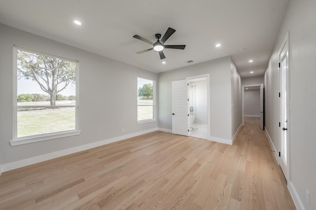 321 El Barco, Corsicana, TX 75109 - unfurnished bedroom featuring light wood finished floors, multiple windows, baseboards, recessed lighting, and ensuite bath