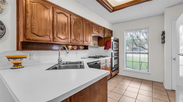 103 Shannon Dr, Allen, TX 75002 - kitchen with a sink, light countertops, a textured ceiling, brown cabinetry, and appliances with stainless steel finishes