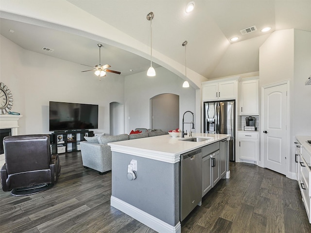 9713 Excursion Dr, Little Elm, TX 75068 - kitchen with a sink, arched walkways, appliances with stainless steel finishes, dark wood-type flooring, and white cabinetry