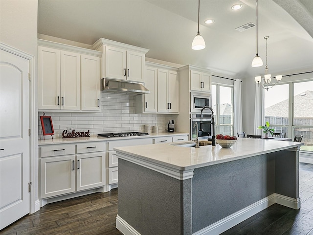9713 Excursion Dr, Little Elm, TX 75068 - kitchen featuring appliances with stainless steel finishes, dark wood finished floors, decorative backsplash, white cabinetry, and recessed lighting