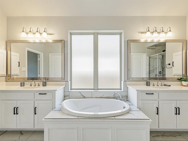 9713 Excursion Dr, Little Elm, TX 75068 - full bathroom featuring marble look tile flooring, a shower stall, two vanities, and a garden tub