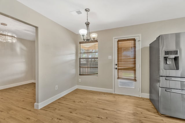 1946 Courtside Dr, Dallas, TX 75051 - unfurnished dining area featuring a chandelier, light wood-style floors, and baseboards