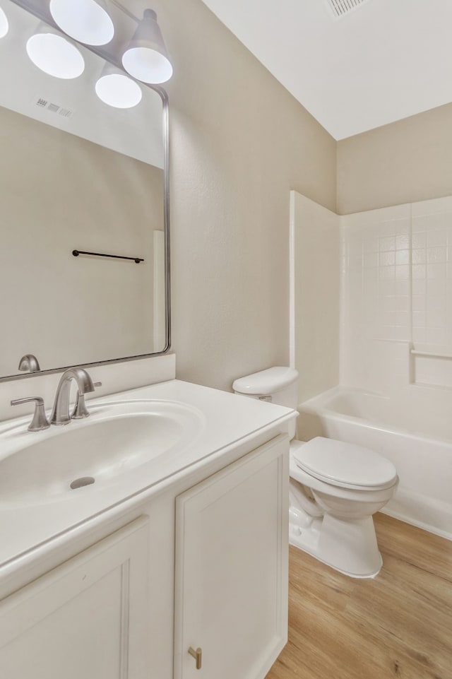 1946 Courtside Dr, Dallas, TX 75051 - bathroom with vanity, toilet, wood finished floors, and bathing tub / shower combination