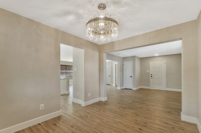 1946 Courtside Dr, Dallas, TX 75051 - spare room featuring light wood-style flooring, baseboards, and a chandelier