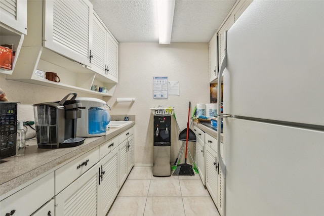 745 Buckner Blvd, Dallas, TX 75218 - kitchen with freestanding refrigerator, open shelves, light tile patterned floors, light countertops, and a textured ceiling