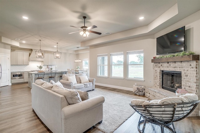 9405 Wildcat Rdg, Godley, TX 76044 - living area featuring recessed lighting, ceiling fan, light wood-style flooring, a brick fireplace, and baseboards