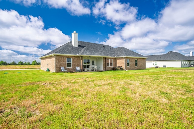 5185 Fox Trot Ln, Caddo Mills, TX 75135 - back of house featuring brick siding, a chimney, a lawn, a patio, and roof with shingles