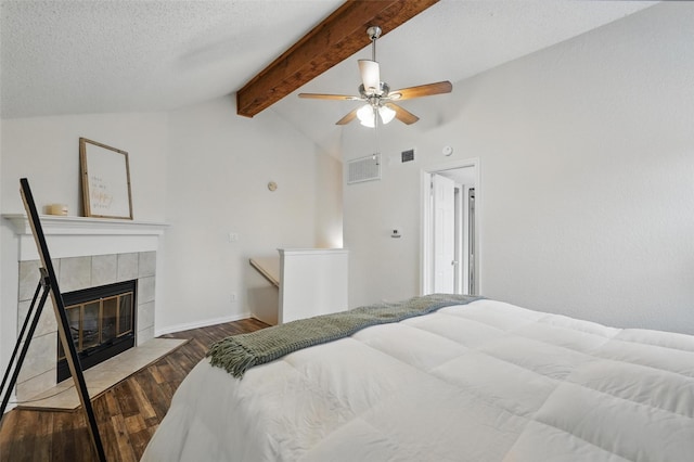 5590 Spring Valley Rd Unit C208, Dallas, TX 75254 - bedroom with wood finished floors, a tiled fireplace, ceiling fan, a textured ceiling, and baseboards