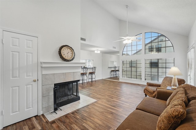 5590 Spring Valley Rd Unit C208, Dallas, TX 75254 - living area featuring ceiling fan, wood finished floors, a tile fireplace, and high vaulted ceiling