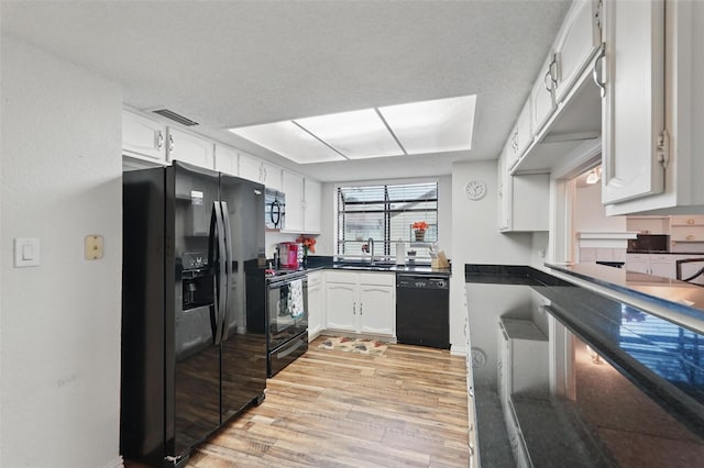 5590 Spring Valley Rd Unit C208, Dallas, TX 75254 - kitchen with black appliances, a sink, light wood-style floors, white cabinetry, and dark countertops