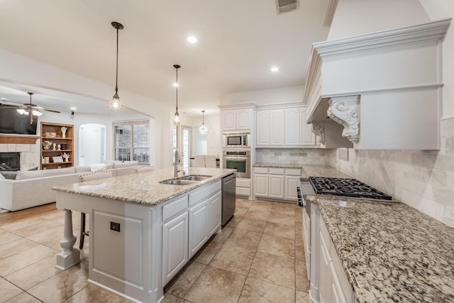 2117 Torin St, Lewisville, TX 75056 - kitchen featuring a sink, appliances with stainless steel finishes, a glass covered fireplace, ceiling fan, and open floor plan