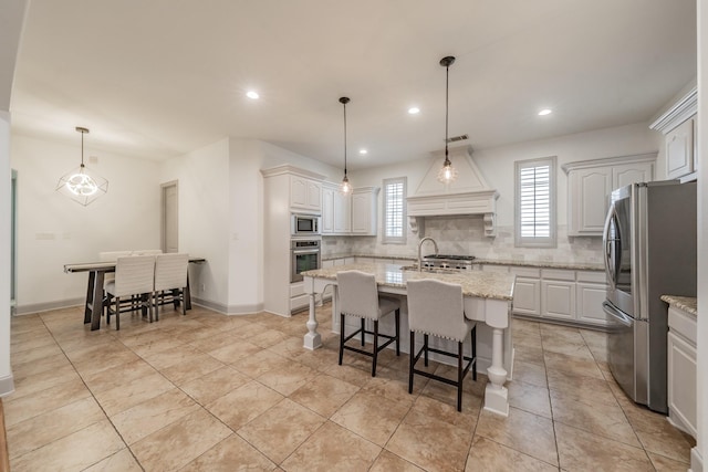 2117 Torin St, Lewisville, TX 75056 - kitchen with appliances with stainless steel finishes, tasteful backsplash, a kitchen island with sink, a sink, and a breakfast bar