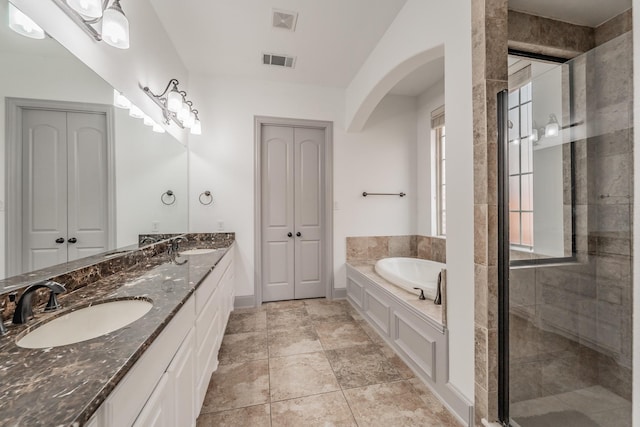 2117 Torin St, Lewisville, TX 75056 - full bathroom featuring a garden tub, double vanity, a shower stall, and baseboards