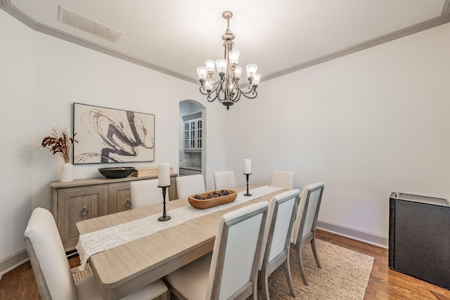 2117 Torin St, Lewisville, TX 75056 - dining room featuring arched walkways, ornamental molding, light wood-style floors, baseboards, and a chandelier