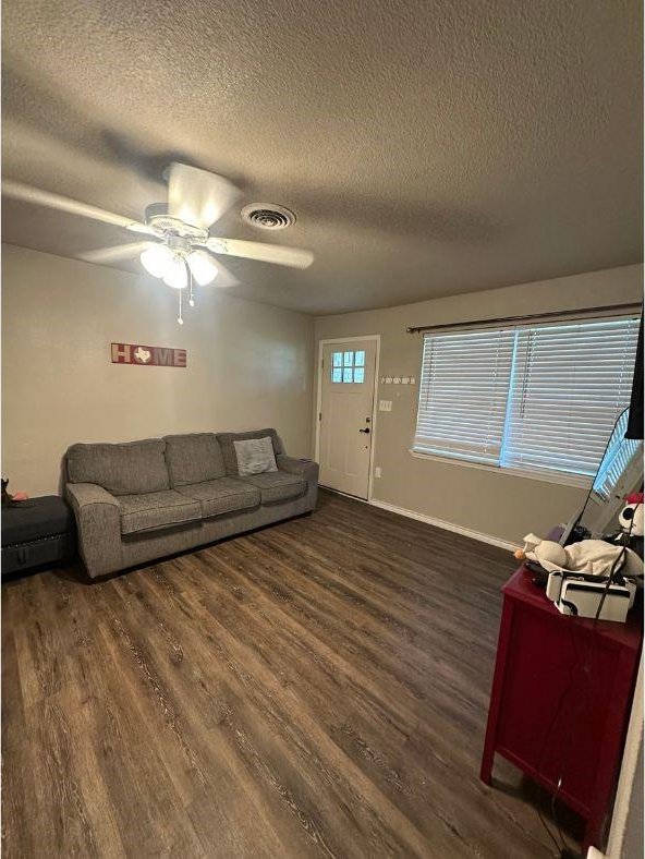 2601 Woodlawn Dr, Ennis, TX 75119 - living area featuring a textured ceiling, wood finished floors, a ceiling fan, and baseboards