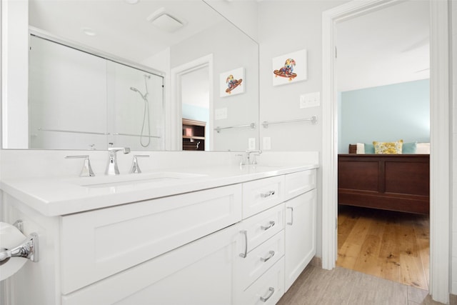 15810 Ranchita Dr, Dallas, TX 75248 - ensuite bathroom featuring double vanity, wood finished floors, and a shower with shower door