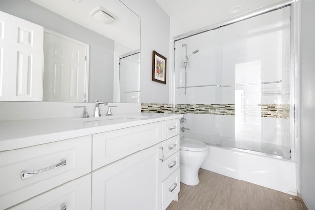 15810 Ranchita Dr, Dallas, TX 75248 - bathroom featuring toilet, vanity, shower / bath combination with glass door, wood finished floors, and tile walls