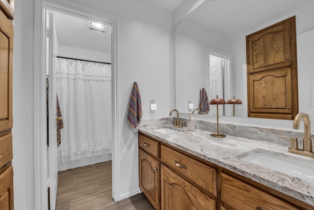 13734 Riverview Dr, Woodway, TX 76712 - bathroom featuring double vanity, wood finished floors, and a shower with curtain