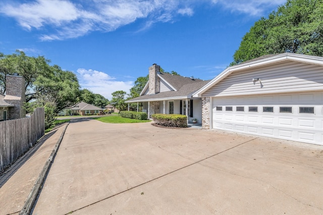 13734 Riverview Dr, Woodway, TX 76712 - view of front of home with concrete driveway, an attached garage, and a chimney