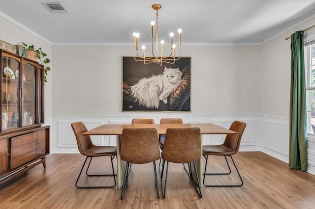 13734 Riverview Dr, Woodway, TX 76712 - dining room with a chandelier, wood finished floors, crown molding, wainscoting, and a decorative wall