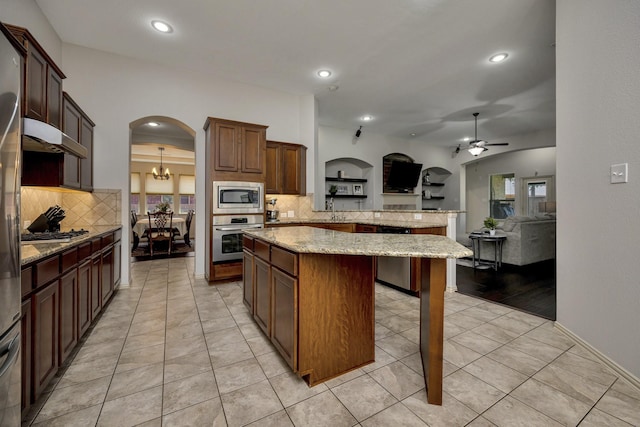 3532 Gallant Trl, Fort Worth, TX 76244 - kitchen with appliances with stainless steel finishes, arched walkways, a peninsula, under cabinet range hood, and tasteful backsplash