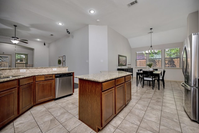 3532 Gallant Trl, Fort Worth, TX 76244 - kitchen featuring stainless steel appliances, a sink, lofted ceiling, brown cabinetry, and light tile patterned floors