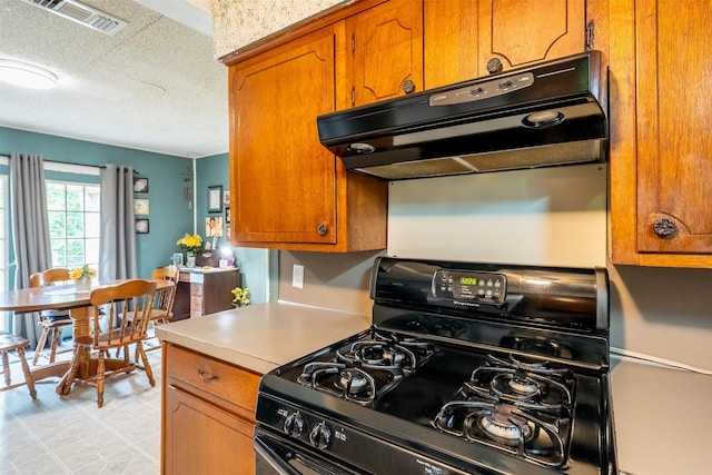 1361 Shady Ln, Canton, TX 75103 - kitchen featuring black range with gas stovetop, brown cabinets, a textured ceiling, exhaust hood, and light countertops