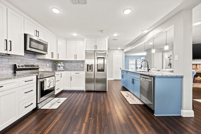2701 Peach Dr, Little Elm, TX 75068 - kitchen with stainless steel appliances, a sink, dark wood-style flooring, white cabinetry, and recessed lighting