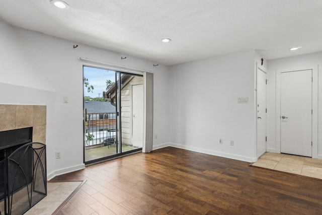 4777 Cedar Springs Rd Unit 6N, Dallas, TX 75219 - unfurnished living room with hardwood / wood-style flooring, recessed lighting, baseboards, and a tiled fireplace