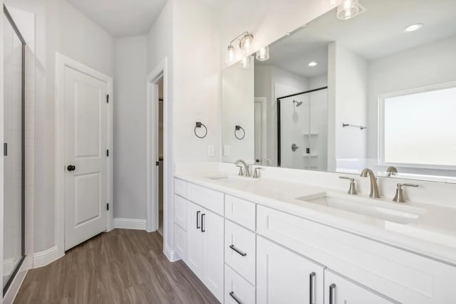 1005 Springfield Dr, Springtown, TX 76082 - bathroom featuring a stall shower, double vanity, wood finished floors, baseboards, and recessed lighting