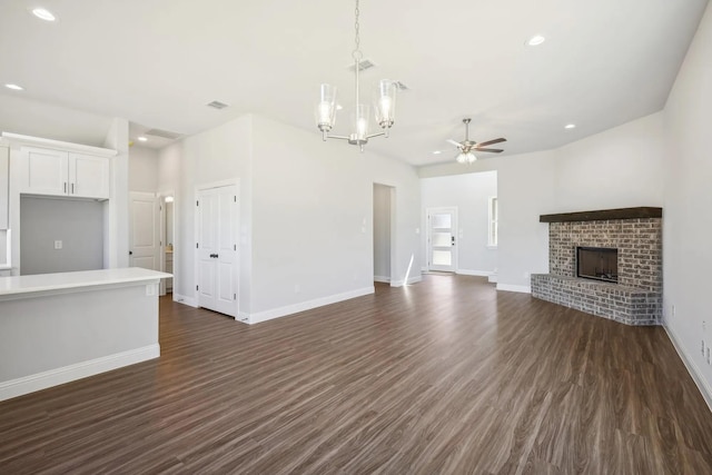 1005 Springfield Dr, Springtown, TX 76082 - unfurnished living room with ceiling fan, dark wood-style flooring, a chandelier, a brick fireplace, and recessed lighting