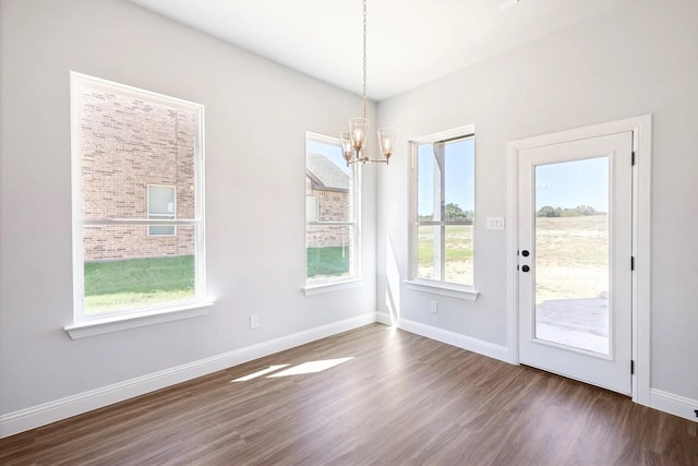1005 Springfield Dr, Springtown, TX 76082 - unfurnished dining area with a chandelier, dark wood-type flooring, and baseboards