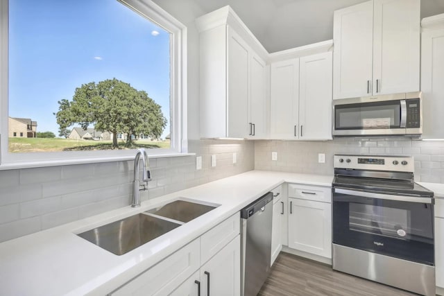1005 Springfield Dr, Springtown, TX 76082 - kitchen featuring stainless steel appliances, a sink, light countertops, and white cabinets