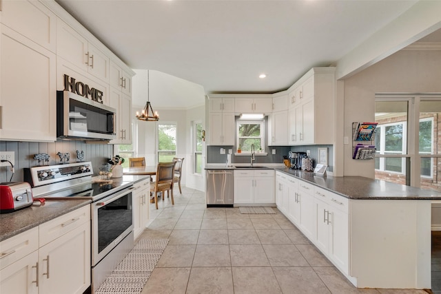15393 Armstrong Rd, Terrell, TX 75160 - kitchen with stainless steel appliances, a peninsula, a sink, white cabinetry, and light tile patterned floors