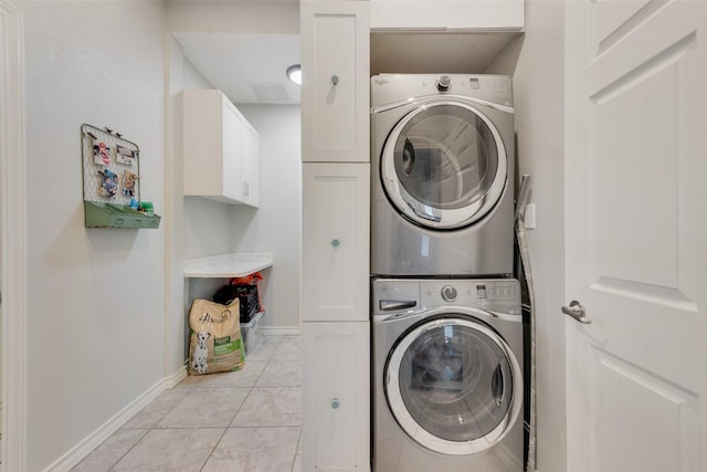 15393 Armstrong Rd, Terrell, TX 75160 - laundry room featuring stacked washer / drying machine, cabinet space, and baseboards