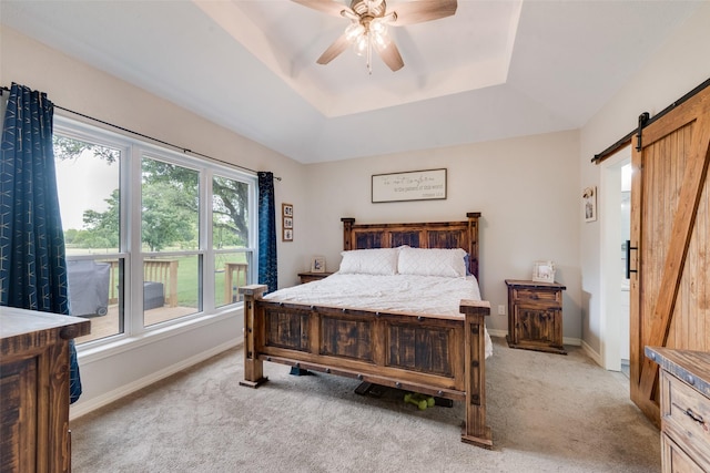15393 Armstrong Rd, Terrell, TX 75160 - bedroom with a raised ceiling, a barn door, light carpet, and a ceiling fan