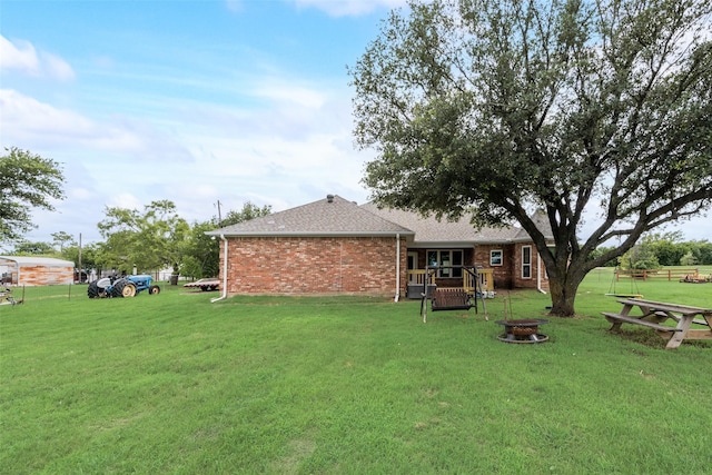 15393 Armstrong Rd, Terrell, TX 75160 - rear view of property with brick siding, an outdoor fire pit, and roof with shingles