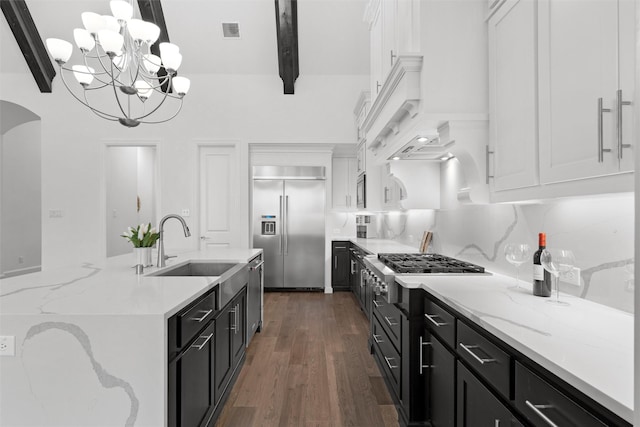 15140 Spider Lily Rd, Frisco, TX 75035 - kitchen featuring built in appliances, a sink, dark cabinetry, a chandelier, and beam ceiling