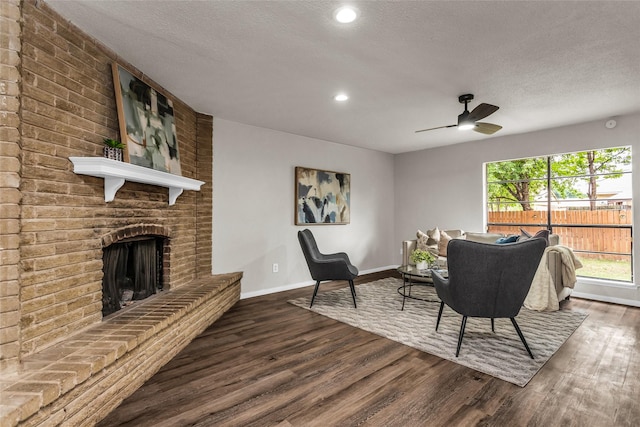 527 Cumberland Dr, Allen, TX 75002 - living area with a fireplace, wood finished floors, baseboards, a ceiling fan, and a textured ceiling