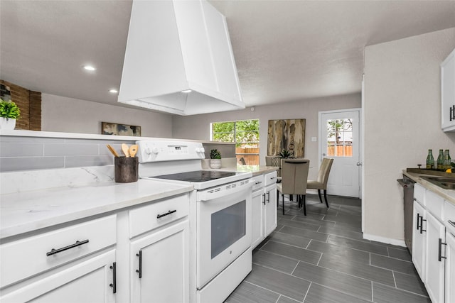 527 Cumberland Dr, Allen, TX 75002 - kitchen with white electric range, white cabinets, recessed lighting, baseboards, and a sink