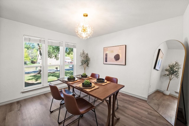 626 Pebblecreek Dr, Garland, TX 75040 - dining area featuring a chandelier, wood finished floors, and baseboards