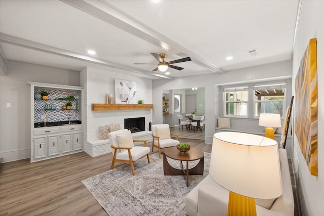 626 Pebblecreek Dr, Garland, TX 75040 - living room with beamed ceiling, light wood finished floors, ceiling fan, recessed lighting, and a fireplace